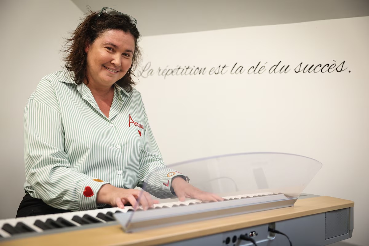 Marie-Ange aan de piano in haar muziekstudio.